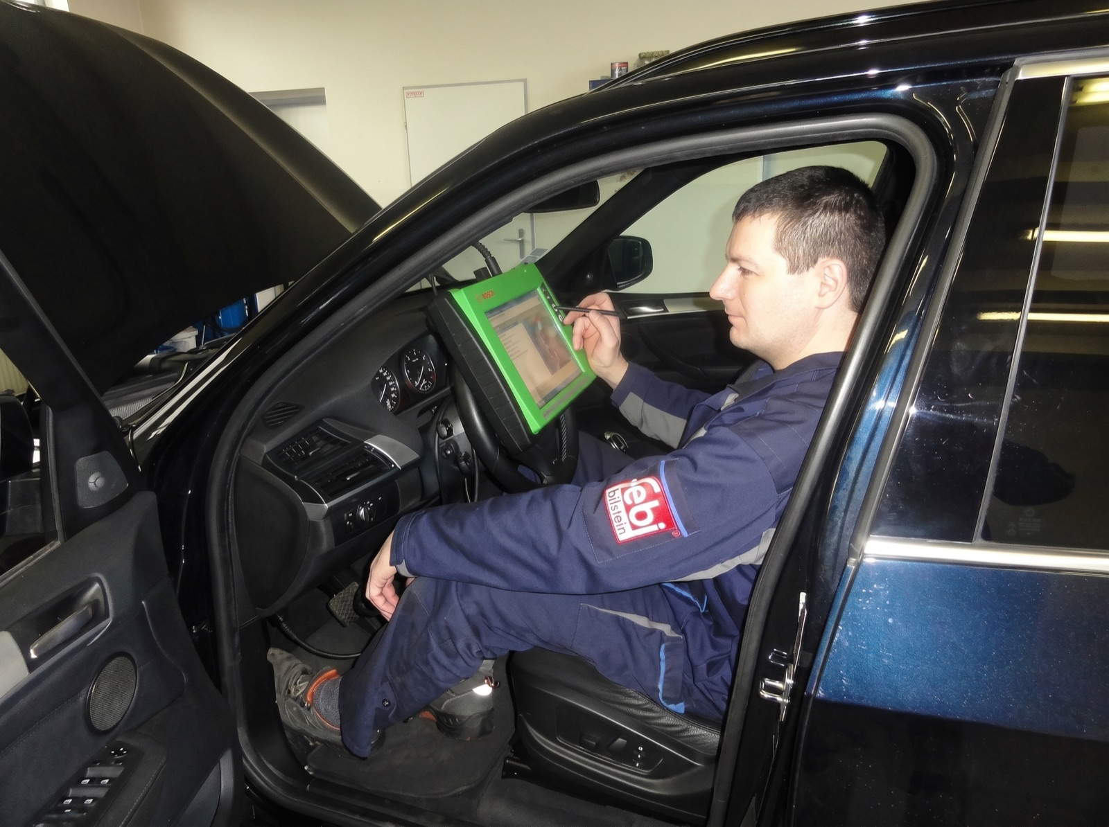 Technik pri počítačovej diagnostike vozidla v dielni CAM